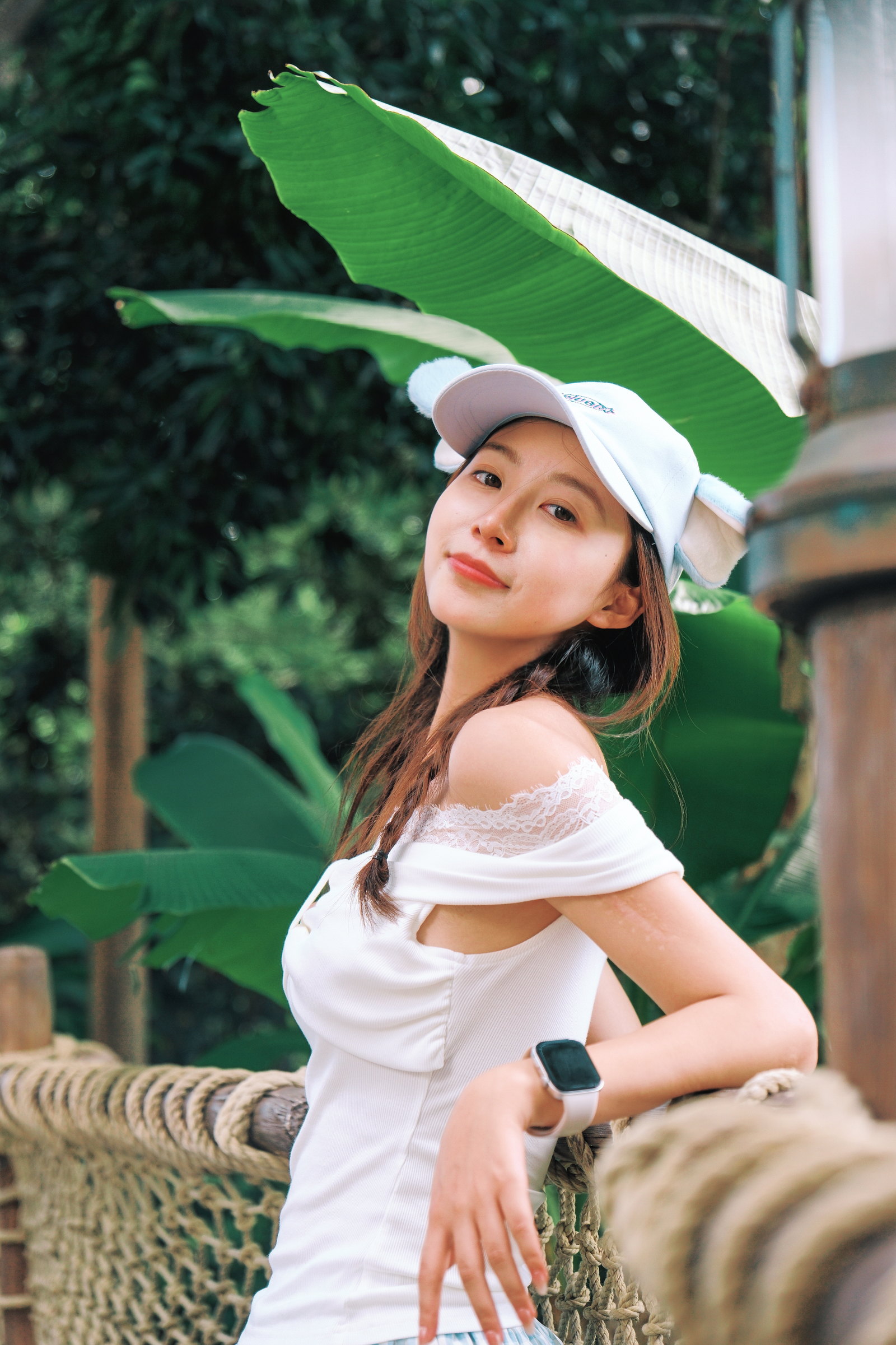 女子戴着一片巨大的绿色叶子